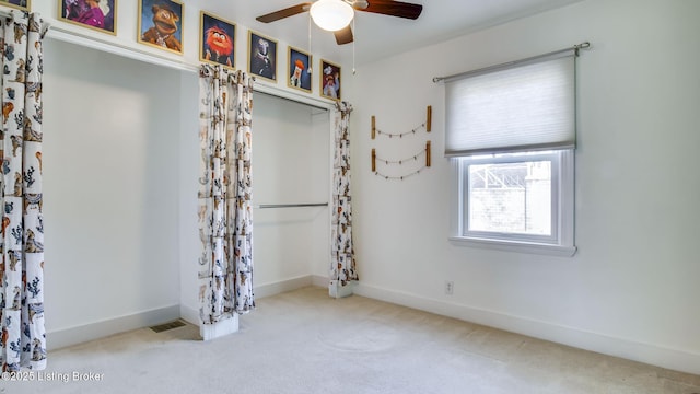 spare room featuring ceiling fan and light carpet