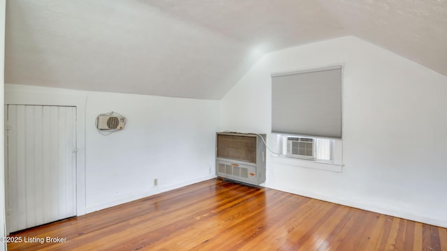 additional living space with vaulted ceiling and wood-type flooring