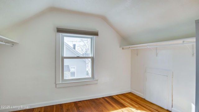 walk in closet featuring light hardwood / wood-style floors and vaulted ceiling