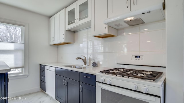 kitchen with tasteful backsplash, white appliances, white cabinets, blue cabinets, and sink