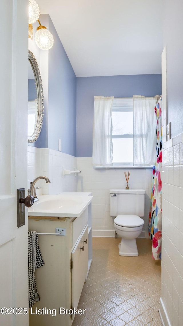 bathroom featuring vanity, tile walls, toilet, and tile patterned flooring