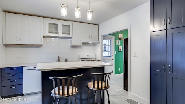 kitchen featuring a center island, white appliances, white cabinets, a breakfast bar area, and pendant lighting