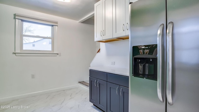 kitchen featuring white cabinets and stainless steel fridge with ice dispenser