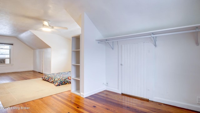 unfurnished bedroom with hardwood / wood-style flooring, ceiling fan, and vaulted ceiling