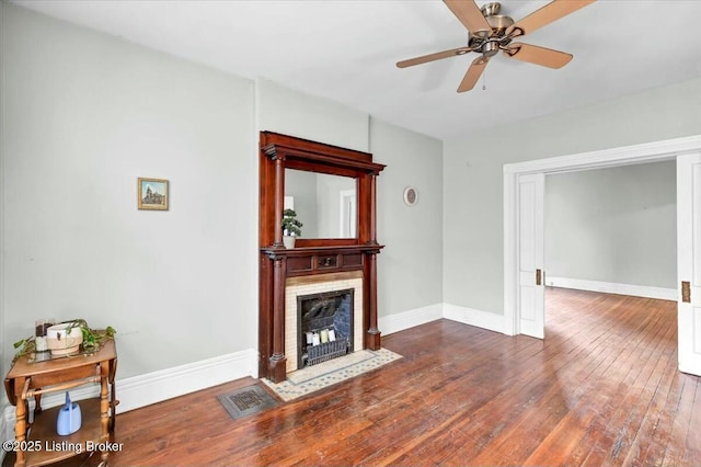 living room with a fireplace, dark hardwood / wood-style floors, and ceiling fan