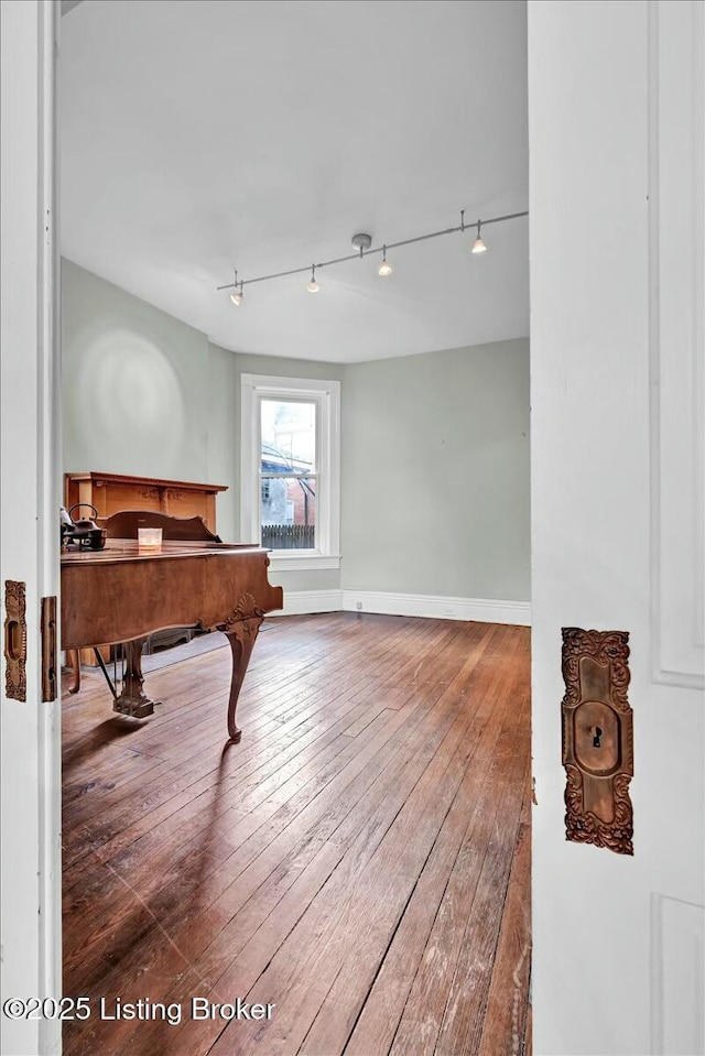 misc room featuring wood-type flooring and rail lighting