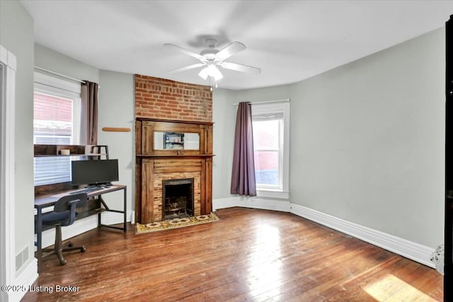 living room featuring a fireplace, dark hardwood / wood-style floors, and a healthy amount of sunlight