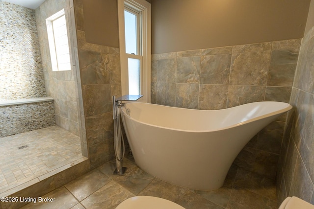 bathroom featuring tile walls and a bath