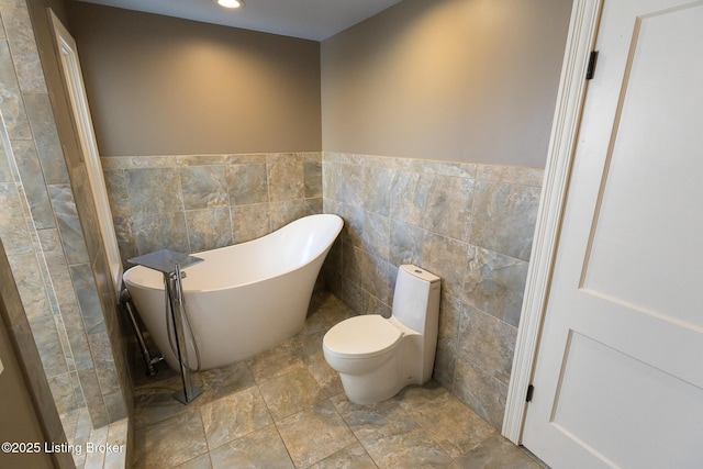 bathroom featuring tile walls, toilet, and a bathing tub