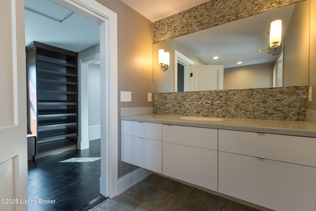 bathroom featuring vanity and backsplash