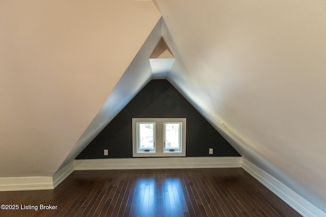 additional living space with dark hardwood / wood-style floors and vaulted ceiling