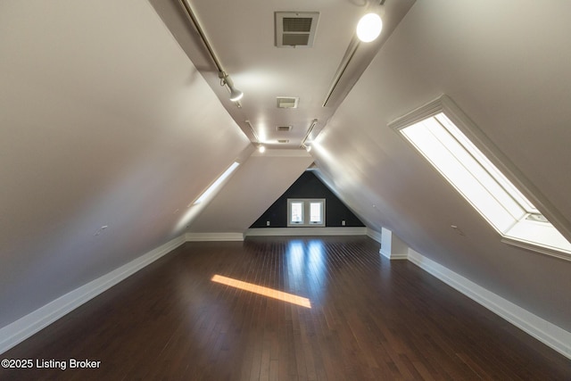 bonus room with dark wood-type flooring and vaulted ceiling