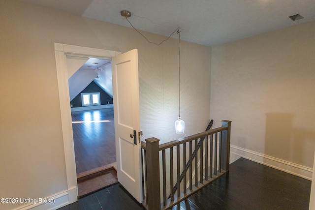 hall featuring vaulted ceiling and dark wood-type flooring