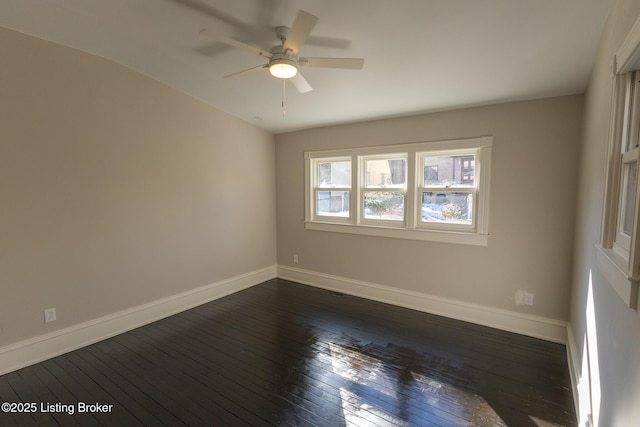 empty room with ceiling fan and dark hardwood / wood-style floors