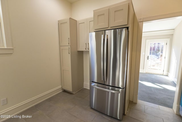 kitchen with light colored carpet and stainless steel refrigerator