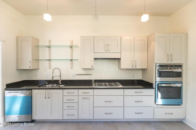 kitchen featuring pendant lighting, sink, white cabinetry, and appliances with stainless steel finishes