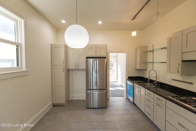 kitchen featuring track lighting, stainless steel appliances, sink, and hanging light fixtures