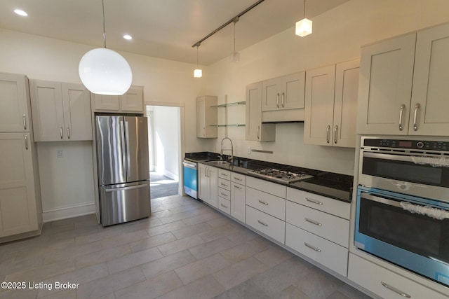 kitchen featuring stainless steel appliances, sink, pendant lighting, and a towering ceiling