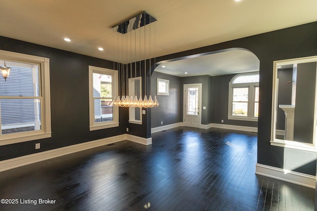 interior space with plenty of natural light and dark hardwood / wood-style floors