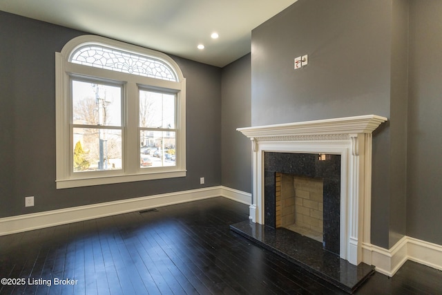 unfurnished living room featuring dark hardwood / wood-style floors and a high end fireplace