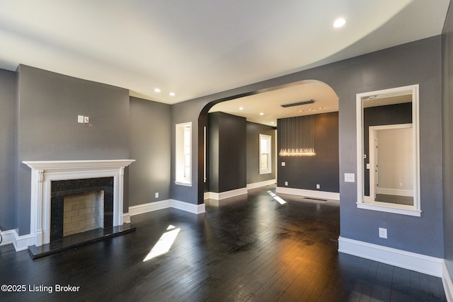 unfurnished living room with a premium fireplace and dark hardwood / wood-style flooring