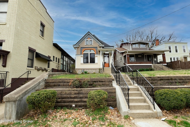 view of front of property featuring stairway and a porch