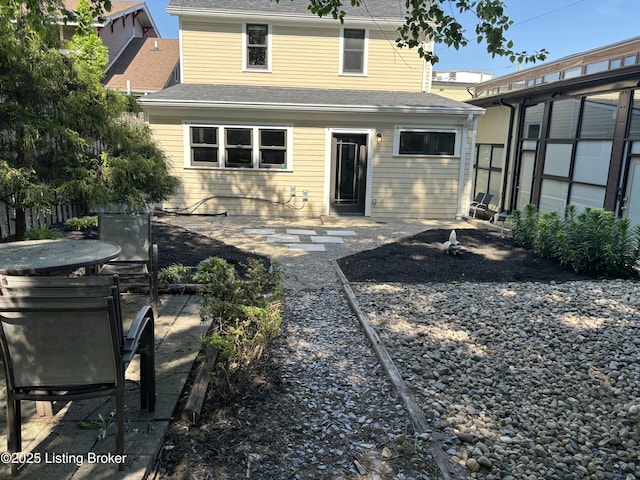 back of house featuring a patio and a shingled roof