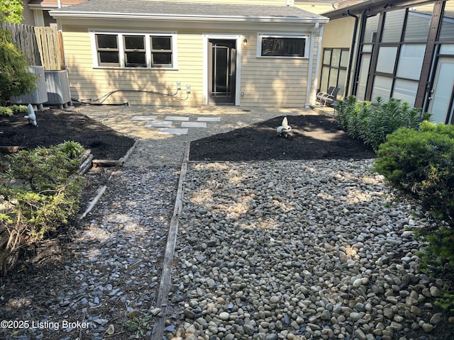 back of house featuring fence and a shingled roof