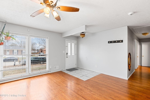 entrance foyer with ceiling fan, light hardwood / wood-style floors, and a textured ceiling