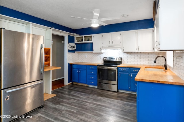 kitchen featuring appliances with stainless steel finishes, blue cabinets, butcher block counters, sink, and white cabinets