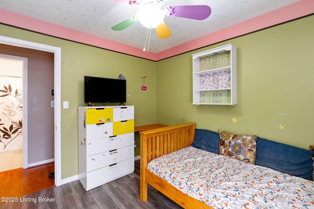 bedroom featuring dark wood-type flooring, ceiling fan, and a textured ceiling