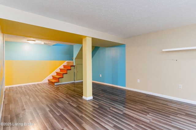 basement featuring wood-type flooring and a textured ceiling