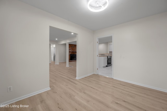 empty room featuring a fireplace and light wood-type flooring