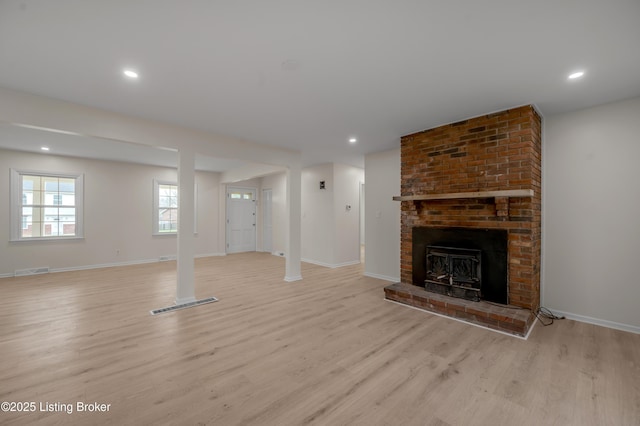 unfurnished living room with a fireplace and light hardwood / wood-style flooring