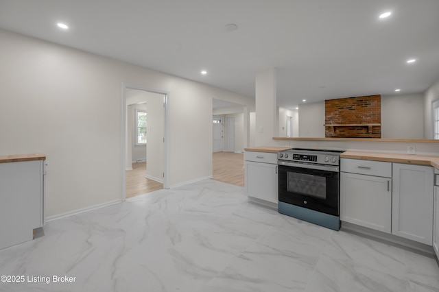 kitchen featuring stainless steel range with electric cooktop and white cabinets