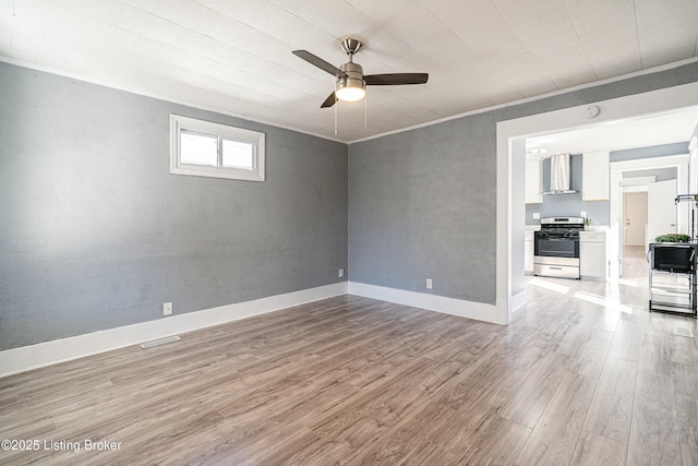 empty room with light hardwood / wood-style flooring, ornamental molding, and ceiling fan