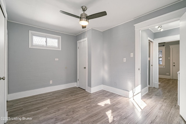 unfurnished bedroom featuring ceiling fan, ornamental molding, wood-type flooring, and a closet