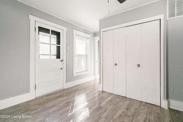 interior space featuring crown molding, a closet, and light wood-type flooring