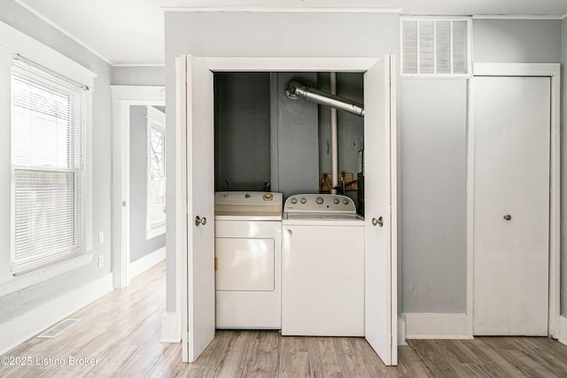 laundry area featuring independent washer and dryer and light hardwood / wood-style flooring