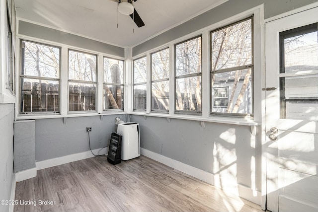 sunroom / solarium featuring ceiling fan