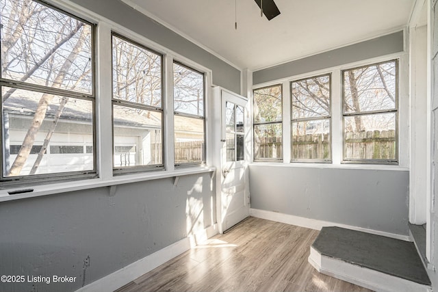 unfurnished sunroom with ceiling fan and plenty of natural light