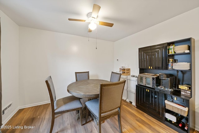 dining space with light hardwood / wood-style flooring and ceiling fan