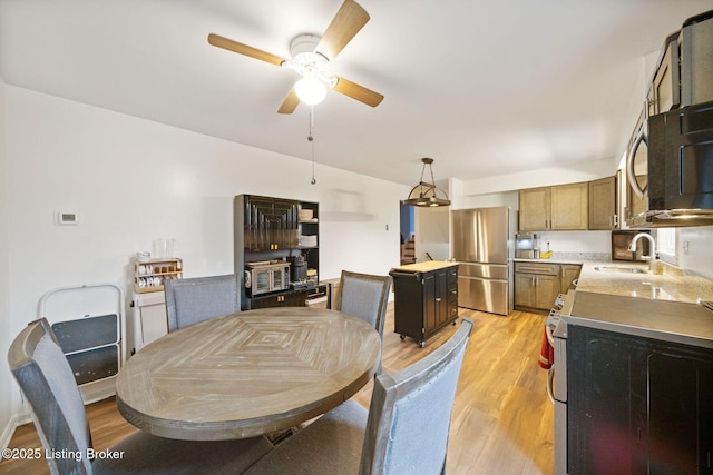 dining space with sink, light hardwood / wood-style flooring, and ceiling fan