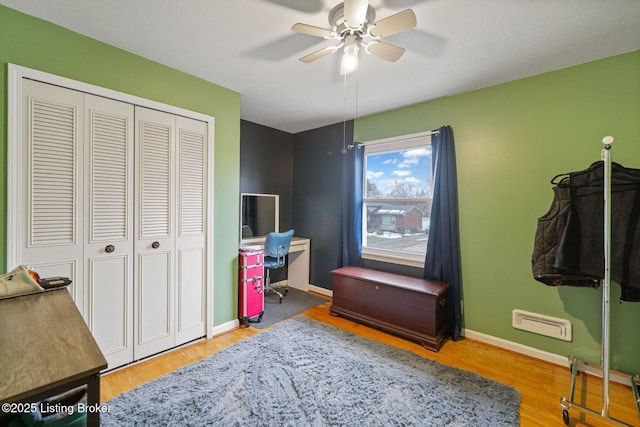 bedroom with ceiling fan, wood-type flooring, and a closet