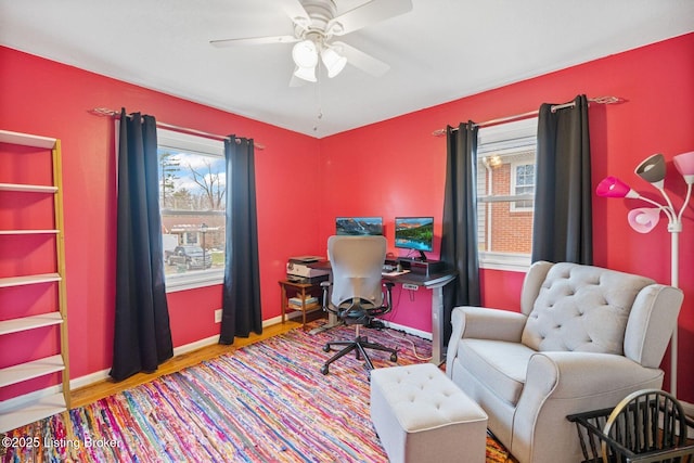 home office with ceiling fan and light hardwood / wood-style flooring