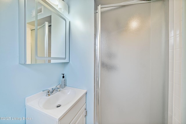 bathroom with vanity and a shower with shower door