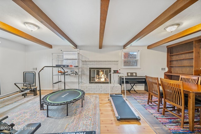 workout room with hardwood / wood-style flooring and a brick fireplace