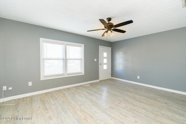 empty room with ceiling fan, a textured ceiling, and light wood-type flooring