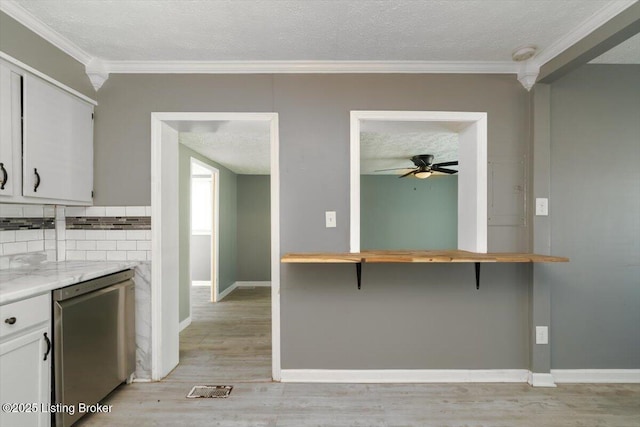 kitchen with refrigerator, white cabinetry, light hardwood / wood-style floors, crown molding, and a textured ceiling