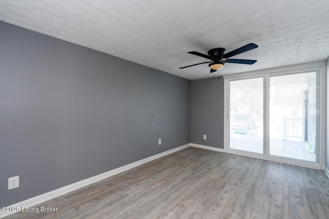 spare room with ceiling fan, light hardwood / wood-style floors, and a textured ceiling